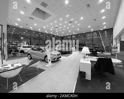 Paris, France - Oct 25, 2019: Black and white image of empty car dealership showroom interior with multiple Seat Cars inside and focus on black Silver Ibiza four door model Stock Photo
