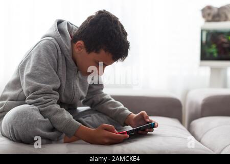 Child with portable games console. video game console for home or portable gaming. Teenager man playing game on console Stock Photo
