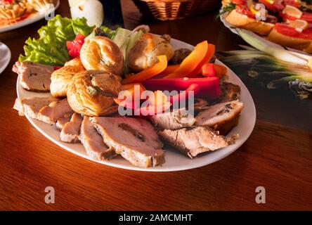 Plate with delicious snacks on a table in a cafe. Tapas, appetizer at the buffet table in a restaurant. Burgers, baked stuffed meat with spices, slice Stock Photo