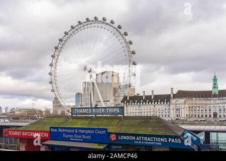 Thames River trips sign along Victoria Embankment with the London Eye in the background, January 2020, London, England, UK Stock Photo
