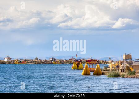 Floating islands of Uros, Lake Titicaca, Peru, South America - 2019-12-01. View of the island, a boat from the reeds, blue sky in the clouds. Stock Photo