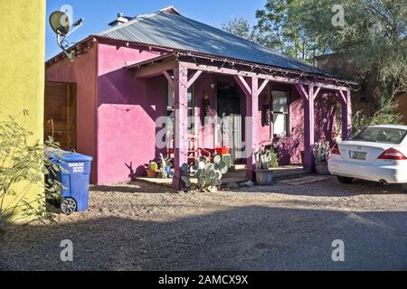 pretty cottage in gentrifying Barrio Historic District Tucson with new corrugated metal roof on house & porch & shocking pink stucco over old facade Stock Photo