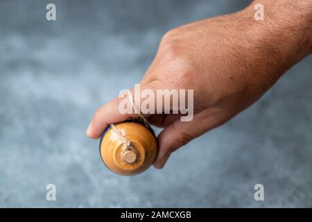 Classic wooden spinning top toy with string Stock Photo
