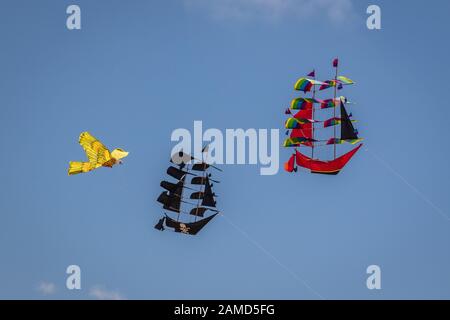 Rainbow colored kites in a shape of tall ships and a bird in the sky, Bali, Indonesia. Stock Photo