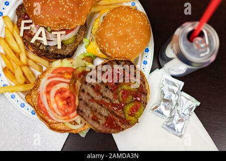 Say No To Junk Food. Juicy burger and fries with word FAT on it. Anti fast food, time for diet concept. Stock Photo