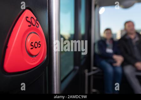 19 December 2019, Lower Saxony, Osnabrück: Passengers sit in the autonomously driving shuttle bus 'Hubi' (Hub Chain is a digital mobility platform for so-called 'on-demand' traffic). In the foreground there is a button ('SOS') for an emergency stop. At present, the Osnabrück public utility company is initially testing the bus on a 1.1-kilometer circuit. Photo: Friso Gentsch/dpa Stock Photo
