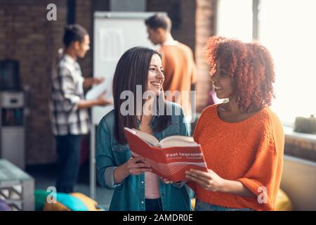 Mulatto student smiling while standing near best friend Stock Photo