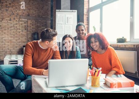 Students laughing while having little break and watching funny video Stock Photo