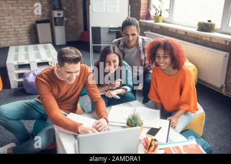 Top view of students making notes while watching webinar together Stock Photo