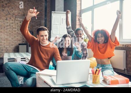 Cheerful students feeling happy while watching webinar together Stock Photo