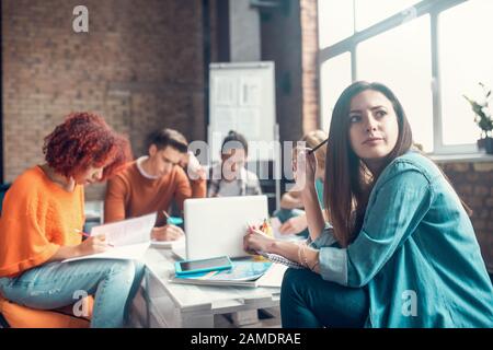 Student wearing denim shirt feeling thoughtful and concerned Stock Photo