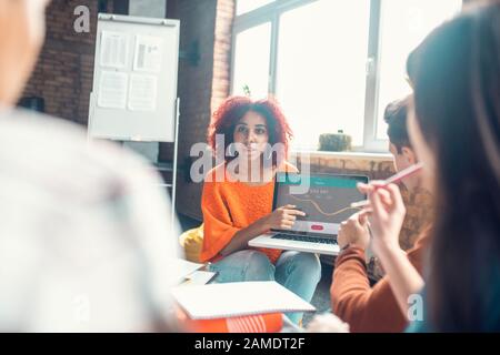 Student speaking with friends while presenting her project Stock Photo