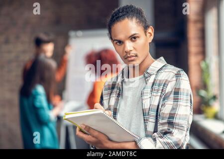 Handsome dark-eyed student feeling concentrated while studying Stock Photo