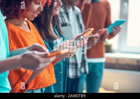 Students using their devices while having addiction to social media Stock Photo