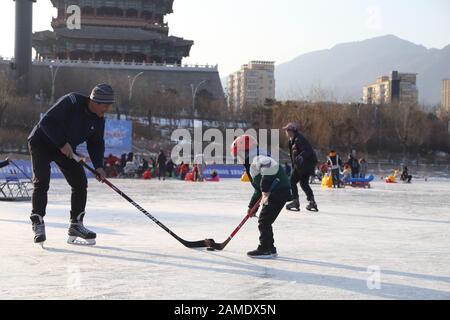 Beijing, China. 12th Jan, 2020. People play ice hockey on a frozen lake in Mentougou District of Beijing, capital of China, Jan. 12, 2020. Credit: Hou Jiqing/Xinhua/Alamy Live News Stock Photo