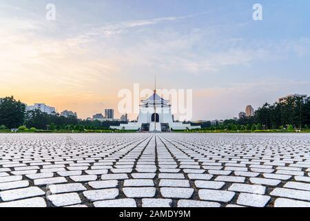 Center view at sunrise of the Chiang Kai Shek Memorial Hall Building with the National Flag Pole and liberty square in front. Stock Photo