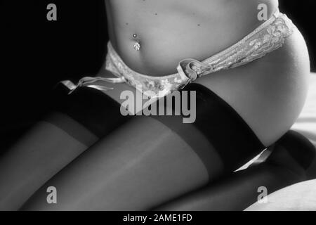 Legs covered from a pair of black nylon stockings with suspender belt Stock Photo