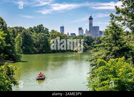 NYC, NY / USA - July 12 2014: View of the Lake of the Central Park with the West Side Manhattan skyline in the background.