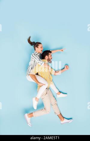 Vertical top view above high angle flat lay flatlay lie concept full length body size view of cheerful couple running hurry-up isolated on bright Stock Photo