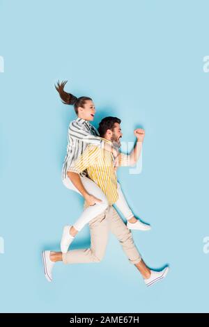Vertical top view above high angle flat lay flatlay lie concept full length body size view of couple running motion having fun isolated on bright Stock Photo