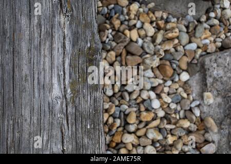 old board and stones on the beach Stock Photo