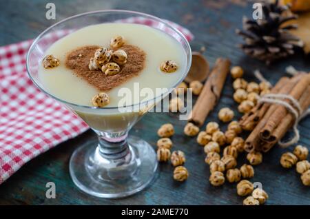 Traditional turkish drink; boza with cinnamon sticks and chickpea on the table. Stock Photo