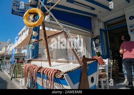 Naxos Greece - August 11 2019;  Octopus tentacles lying over side of boats outside restaurant in torurist area. Stock Photo