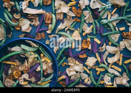 Healthy vegan snacks. Vegetable crisps on slate pattern Stock Photo
