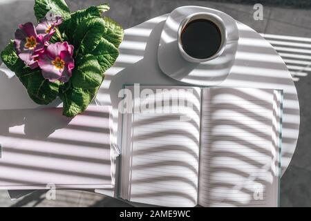 An open notebook on a white table with nice decoration. Bird eye view, mock-up concept Stock Photo