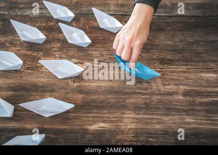 paper boats on aline on the wooden background, concept teamwork, leadership and management Stock Photo
