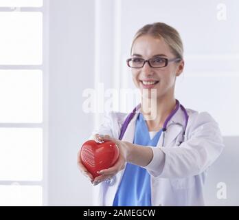 Doctor with stethoscope holding heart, isolated on white background Stock Photo
