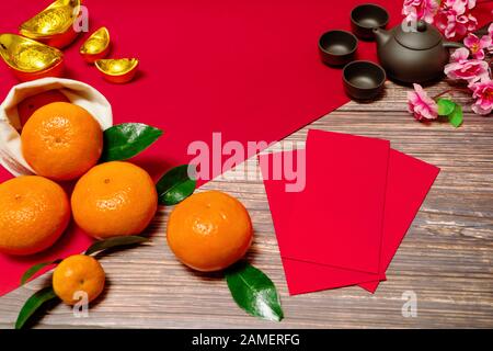 Chinese New Year orange offering red envelope and chinese tea pot, Translation of text appear in image: Prosperity, rich and healthy Stock Photo