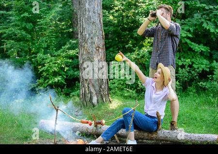 Couple enjoy hike in forest observing nature. Couple ornithologists expedition in forest. Woman and man looking binoculars near bonfire. Observing nature concept. Ornithology interesting occupation. Stock Photo