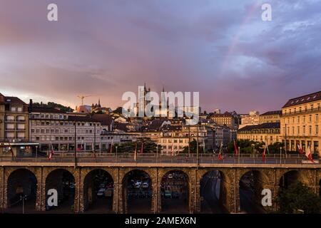 Dramatic sunset over the Grand Pont bridge in the heart of Lausanne Flon historic district with the cathedral in the background in Switzerland Stock Photo