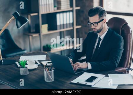 Profile photo of handsome business guy notebook table chatting colleagues partners seriously reading corporate report wear specs black blazer shirt Stock Photo