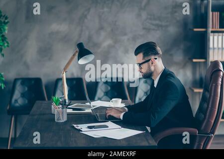 Profile photo of handsome chief business guy notebook table chatting colleagues seriously reading corporate report wear specs black blazer shirt suit Stock Photo