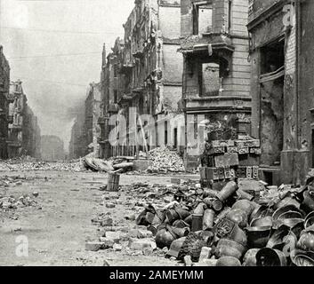 Wermacht’s equipment on Breslau street after the Nazi garrison surrendered to the Red Army troops: German steel helmets, gas masks, ammunition boxes. Stock Photo