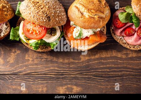 Assorted sandwiches on wooden table Stock Photo