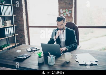 Photo of attentive handsome business brunet guy notebook table chatting colleagues partners reading reports wear black blazer white shirt suit sitting Stock Photo