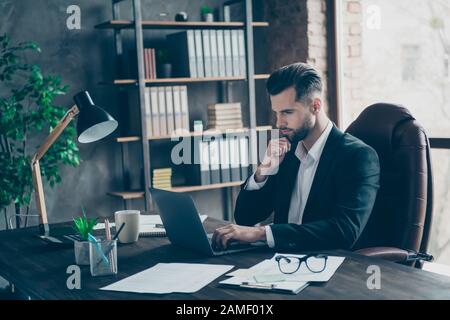 Profile photo of curious business brunet guy looking notebook table reading colleagues email letters analyzing reports wear blazer shirt suit sitting Stock Photo