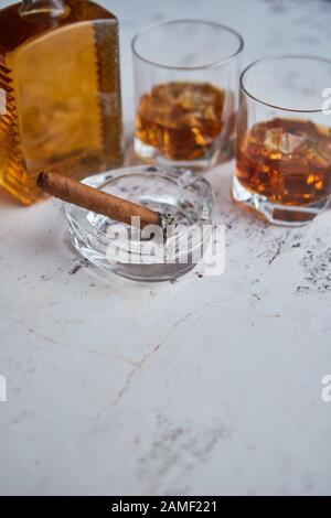 Bottle and glasses of brandy or wiskey and nice big cuban cigar Stock Photo
