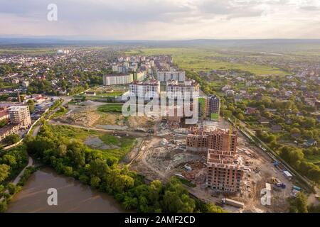 Apartment or office brick buildings under construction, top view. Building site with tower cranes from above. Drone aerial photography. Stock Photo
