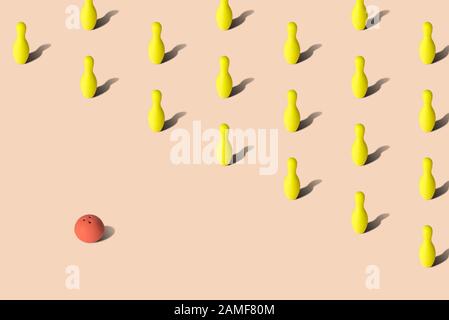 Red bowling ball and yellow bowling pins on pastel background sport abstract. Stock Photo