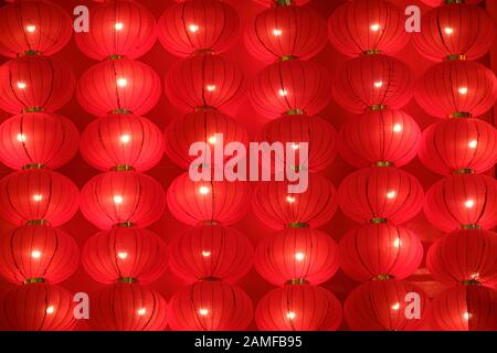 Background of Chinese red lanterns lunar new year decorations hanging on the wall. Stock Photo