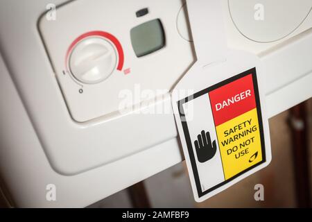Gas safety warning sign on a faulty broken gas boiler Stock Photo