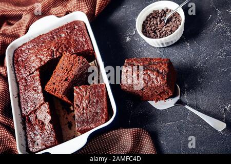 close-up of delicious freshly baked homemade chocolate sponge cake slices in a baking dish on a concrete table Stock Photo