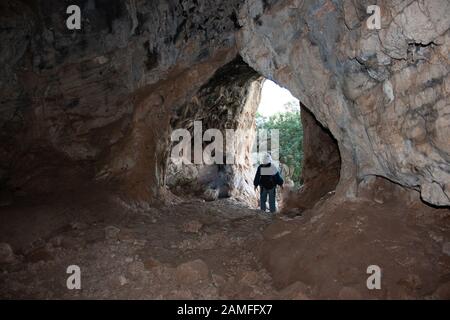 A group of people explore a cave. Photographed in the Carmel mountain range, Israel Stock Photo