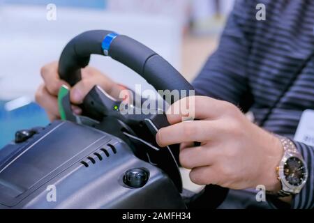Man using gaming steering wheel joystick at technology exhibition Stock Photo