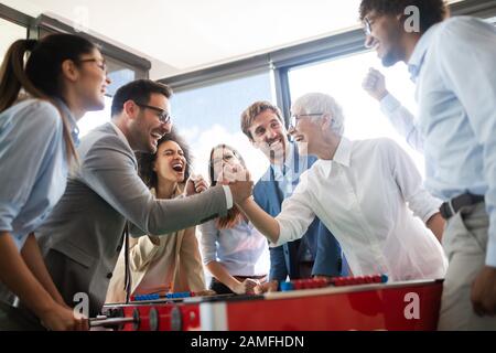 Multiracial people having fun in office room, excited diverse employees enjoying activity at work Stock Photo