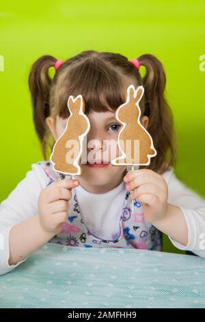 Beautiful girl holds gingerbread cookies in the form of a rabbit. Easter gingerbread cookie Stock Photo